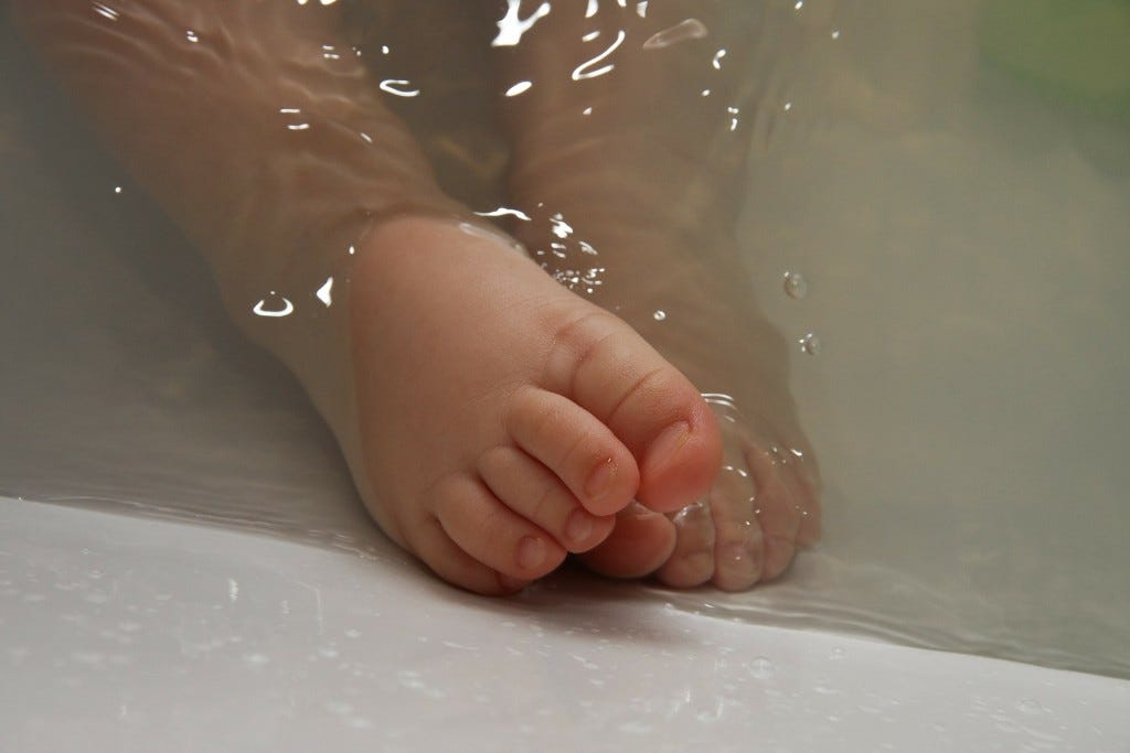 bebé dentro de água com pés de fora bebé dentro de água com pés de fora