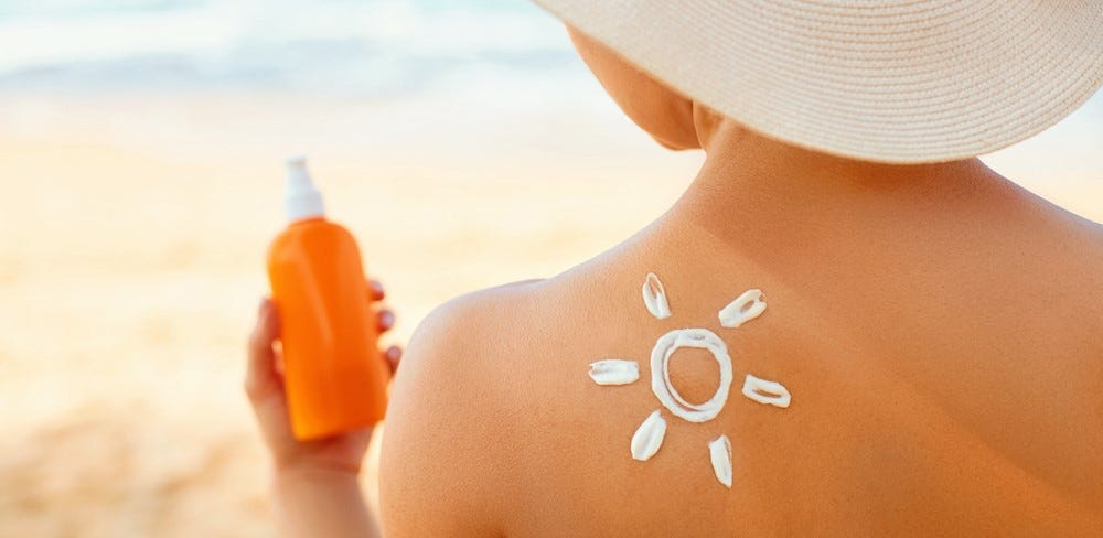 pessoa a segurar o protetor solar na praia pessoa a segurar o protetor solar na praia