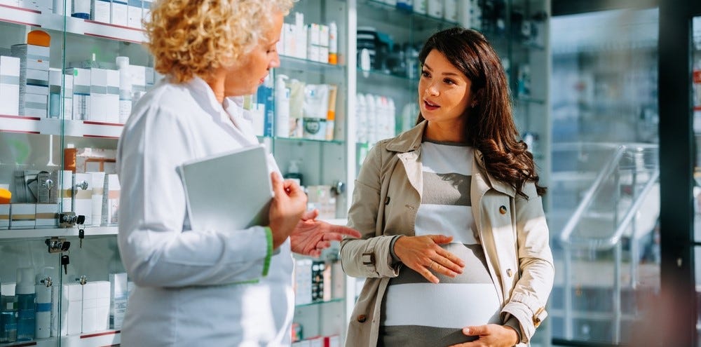 mulher grávida a falar com a farmacêutica mulher grávida a falar com a farmacêutica